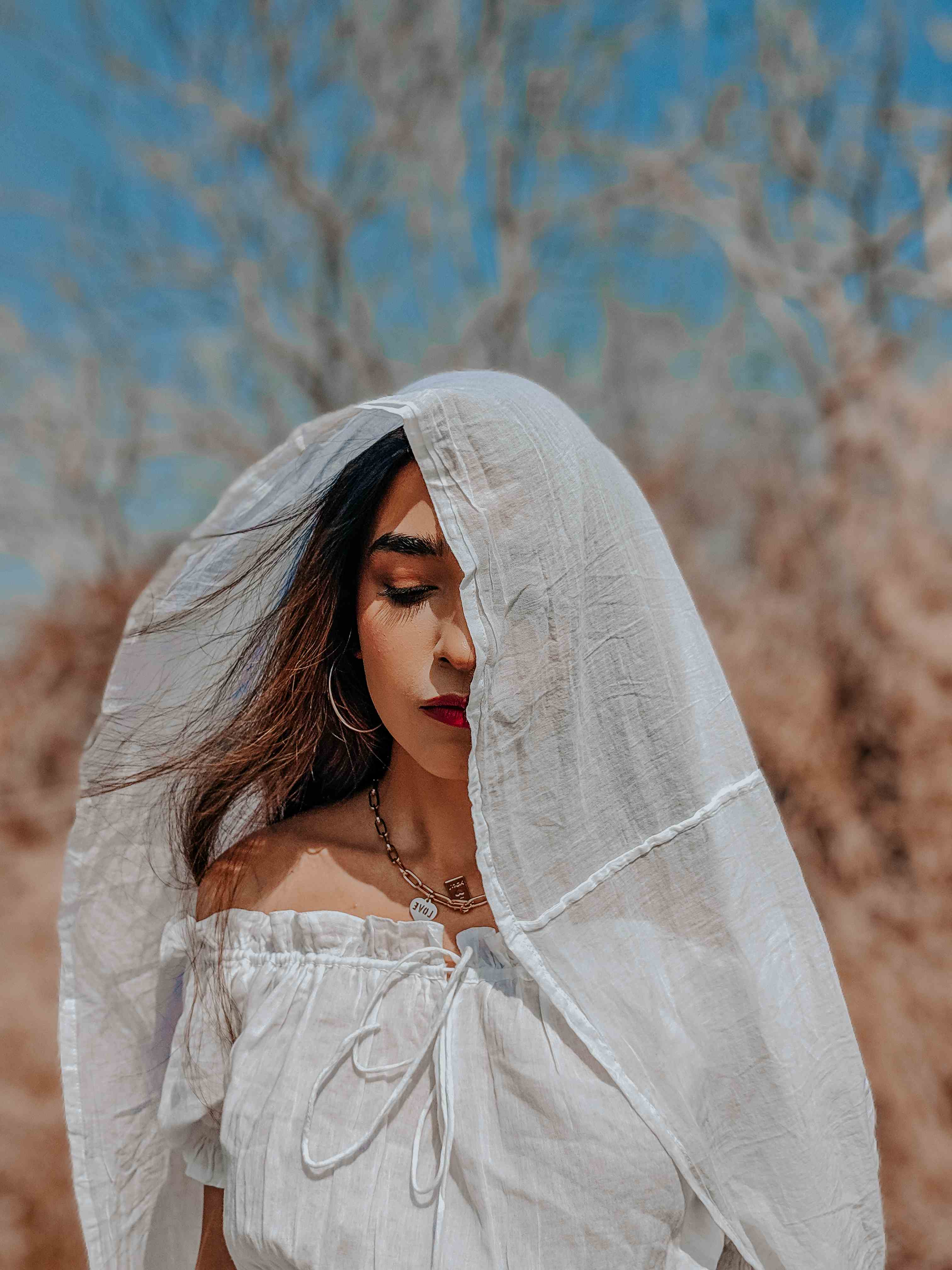 Outdoor editorial fashion shoot with girl in white dress & veil